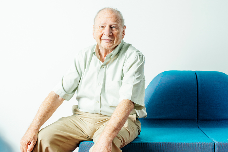 Hal Abelson seated on a blue sofa in a well lit room