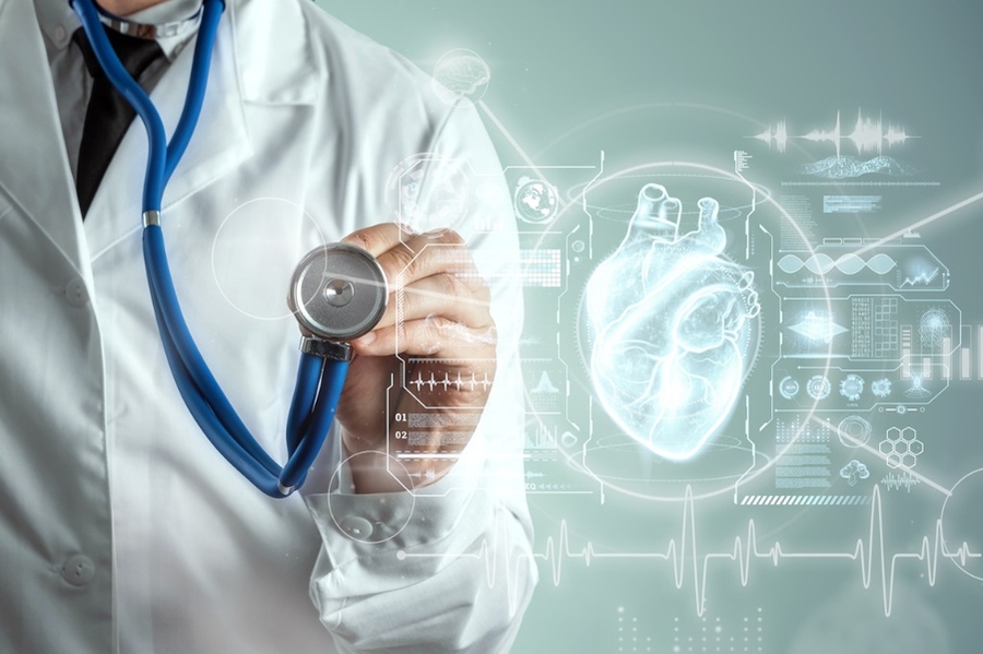 Stock photo of a doctor holding a stethoscope up to a heart hologram