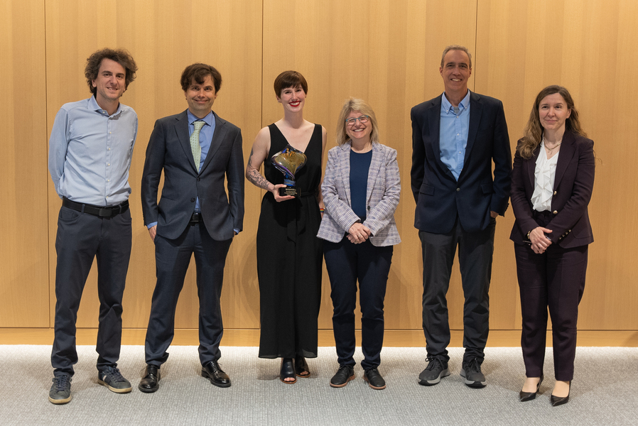 Essay winner Annaliese Meyer (middle, holding trophy) stands with (left to right) Nikos Trichakis, interim associate dean of SERC and associate professor of operations management; Caspar Hare, associate dean of SERC and professor of philosophy; MIT president Sally Kornbluth; Dan Huttenlocher, dean of the MIT Schwarzman College of Computing; and Asu Ozdaglar, deputy dean of academics for the MIT Schwarzman College of Computing and head of the Department of EECS (Credits: Eric Fletcher).