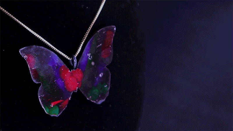MorphoChrome’s programmable color process adds a luminous touch to things like a necklace charm of a butterfly. What started as a static, black accessory became a shiny pendant (Credits: Courtesy of the researchers).